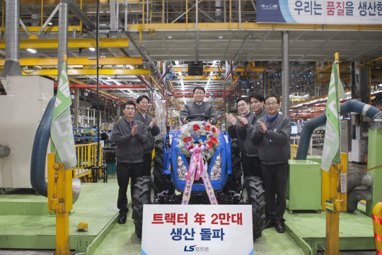 지난 17일 전북 완주군 LS엠트론 트랙터 공장에서 열린 연 2만대 생산 돌파 기념식에서 김연수 LS엠트론 대표이사 사장(왼쪽 세번째)과 어진호 노조위원장(왼쪽 다섯번째) 등 주요 인사들이 2만 번째 생산되는 트랙터 XG3140 모델과 함께 기념 촬영을 하고 있다. <LS엠트론 제공>